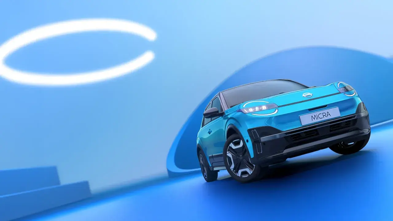 El Nissan Micra azul, con sus modernas luces y diseño, se presenta sobre un fondo abstracto. Conoce las medidas del Nissan Micra.