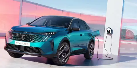 Un nuevo Peugeot E-3008 eléctrico enchufable, de color azul turquesa, cargando en un moderno punto de recarga.