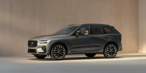 El elegante Volvo XC60 2026, un SUV moderno en color gris oscuro, se exhibe con sus distintivas llantas y líneas aerodinámicas.