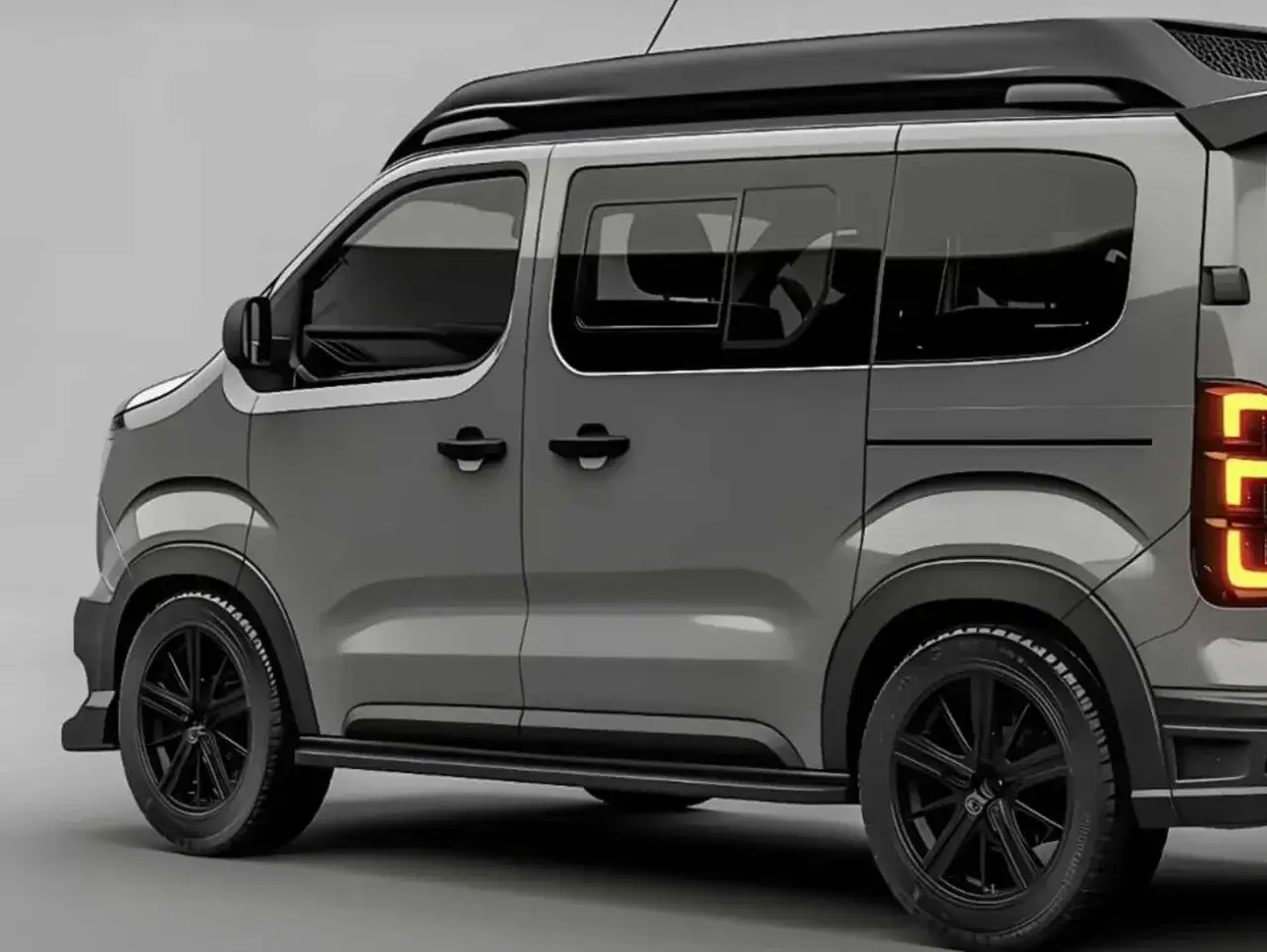 Vehículo gris con techo negro y llantas negras. Sus puertas correderas facilitan el acceso a este coche familiar.