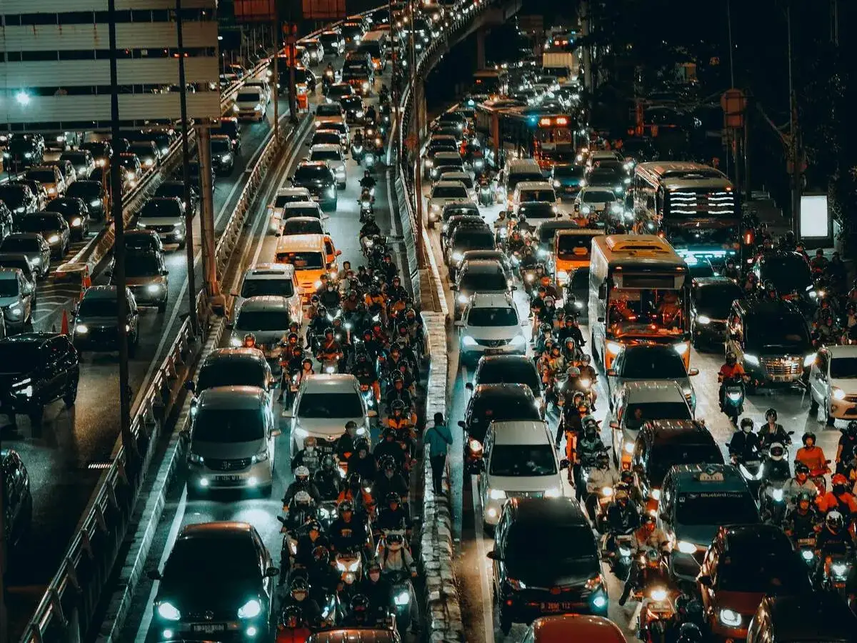 Atasoche de veh&iacute;culos y motocicletas en una autopista nocturna, un ejemplo de la compleja movilidad urbana.