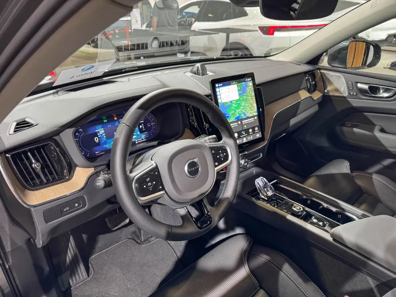Interior del volvo xc60 2026, con pantalla táctil central, volante multifunción y panel de instrumentos digital.