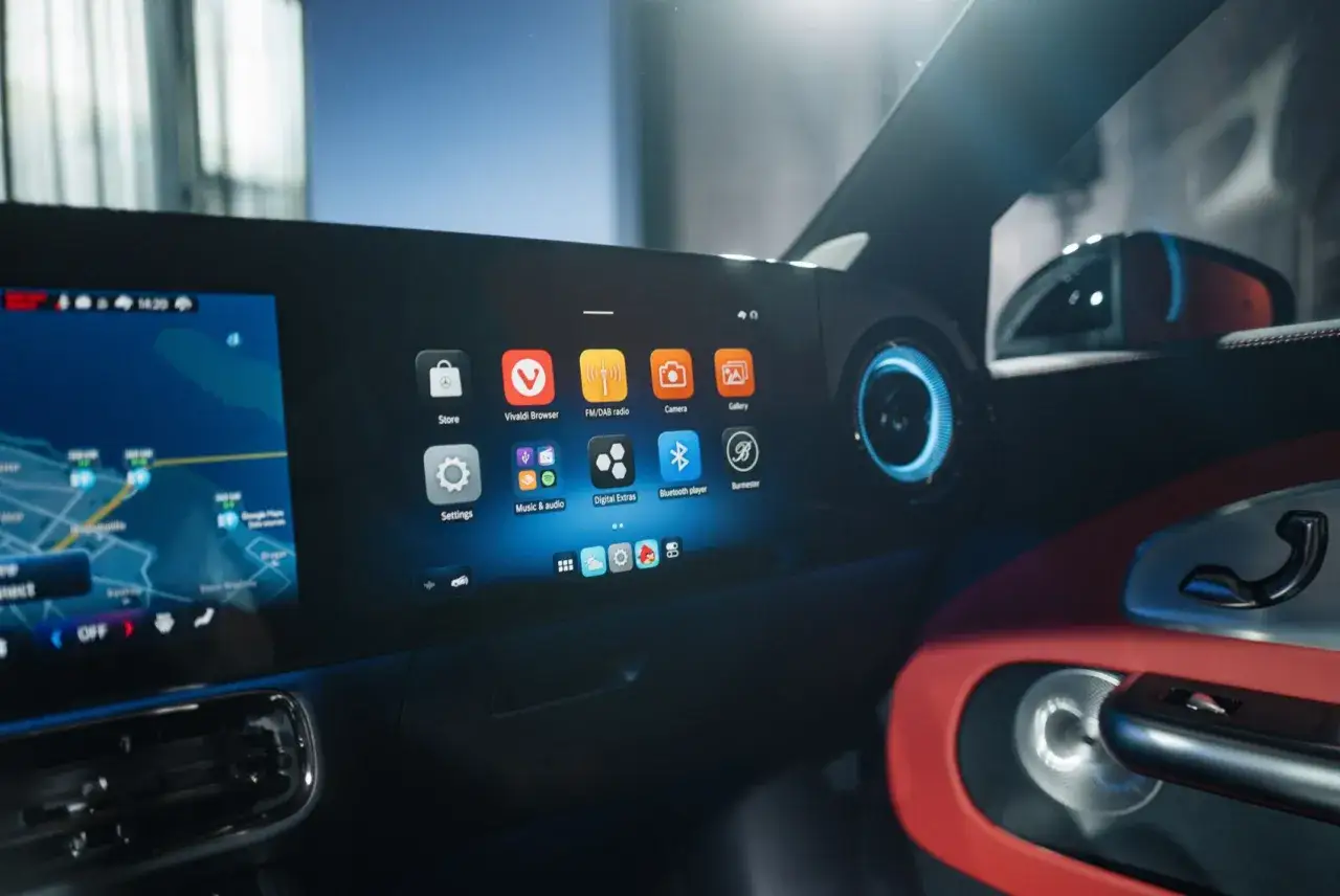 Interior de un coche con pantalla t&aacute;ctil mostrando apps como navegador y m&uacute;sica. El sistema de infoentretenimiento del Denza Z9 GT ofrece una experiencia moderna.