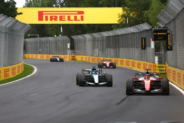 Coches de Fórmula 1 compiten en una curva, con el cartel de Pirelli al fondo. ¡Emocionantes noticias de Fórmula 1!